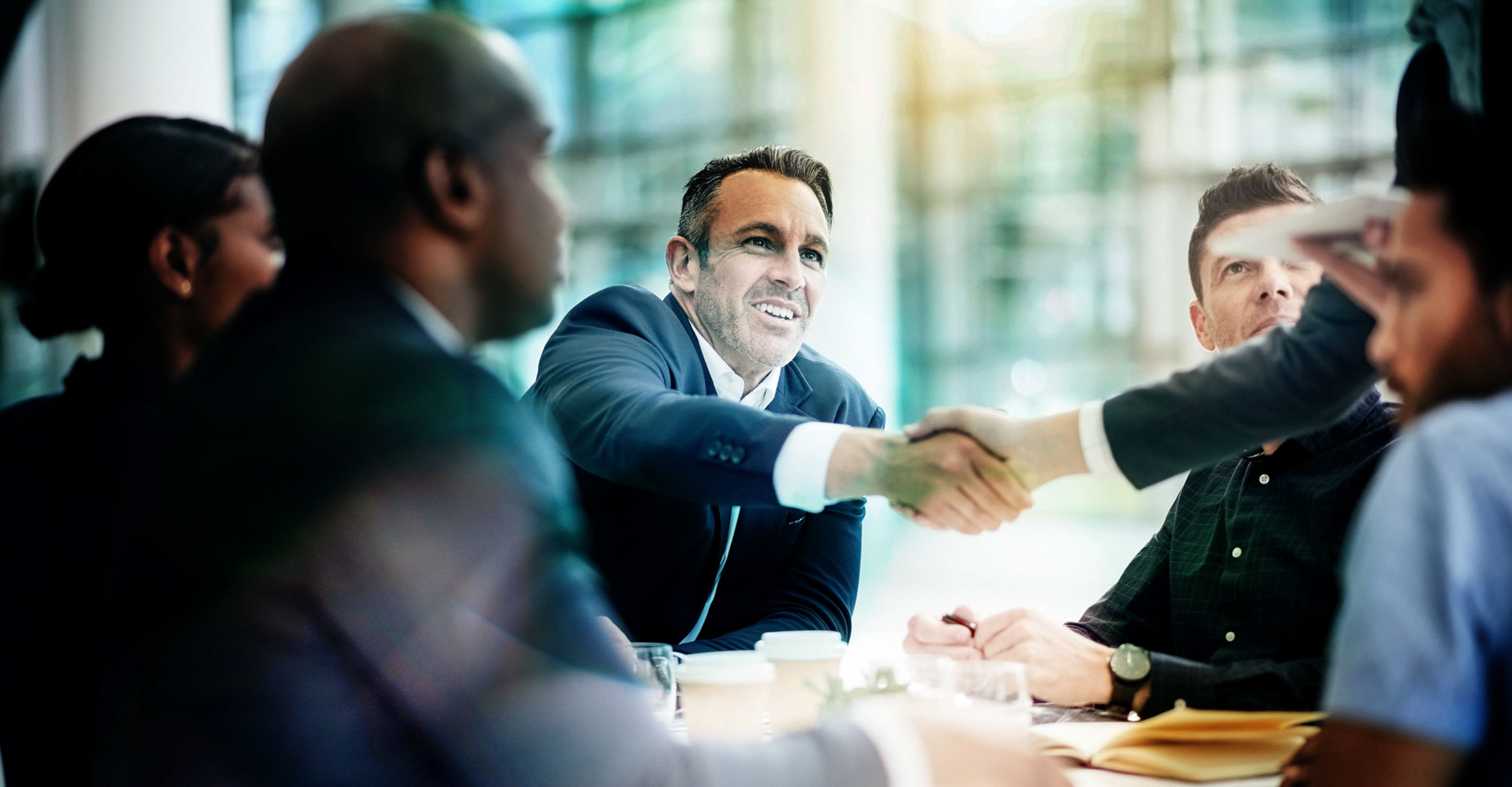 Shot of businesspeople shaking hands during a meeting in an office