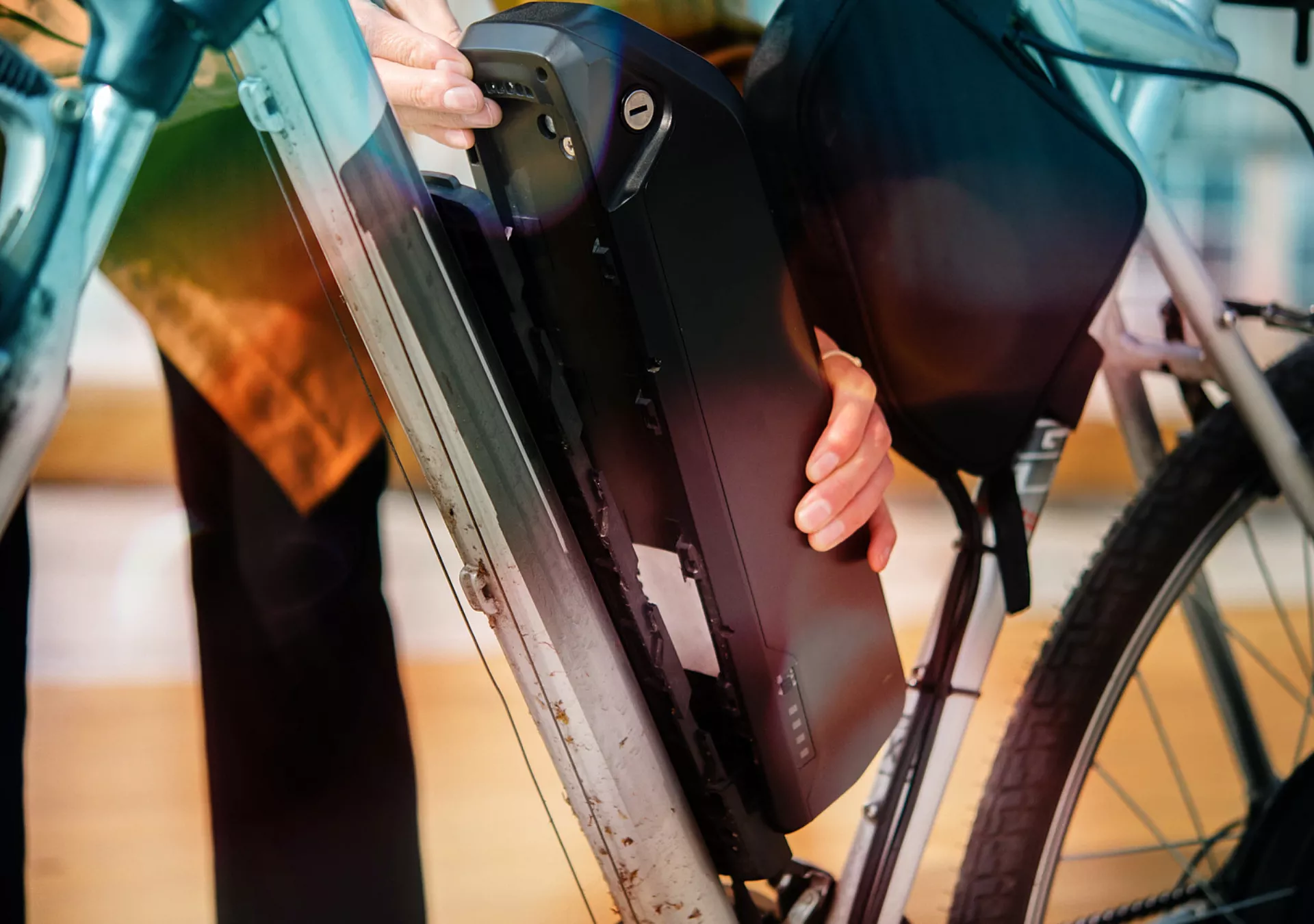 Unrecognizable woman changing battery on her electric bicycle
