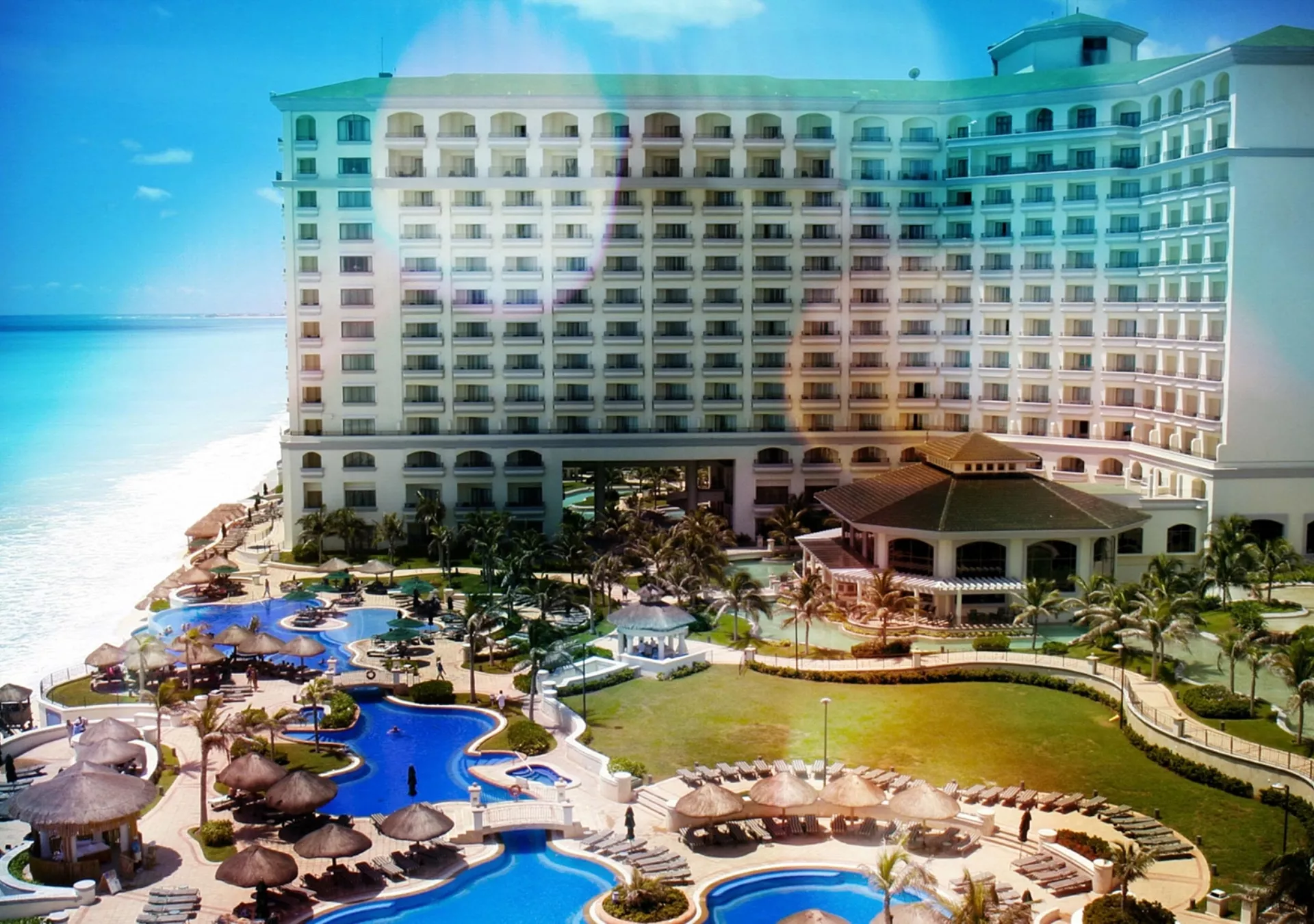 Aerial view of a Cancun resort. There's several large pools and a multi-level hotel at this resort.
