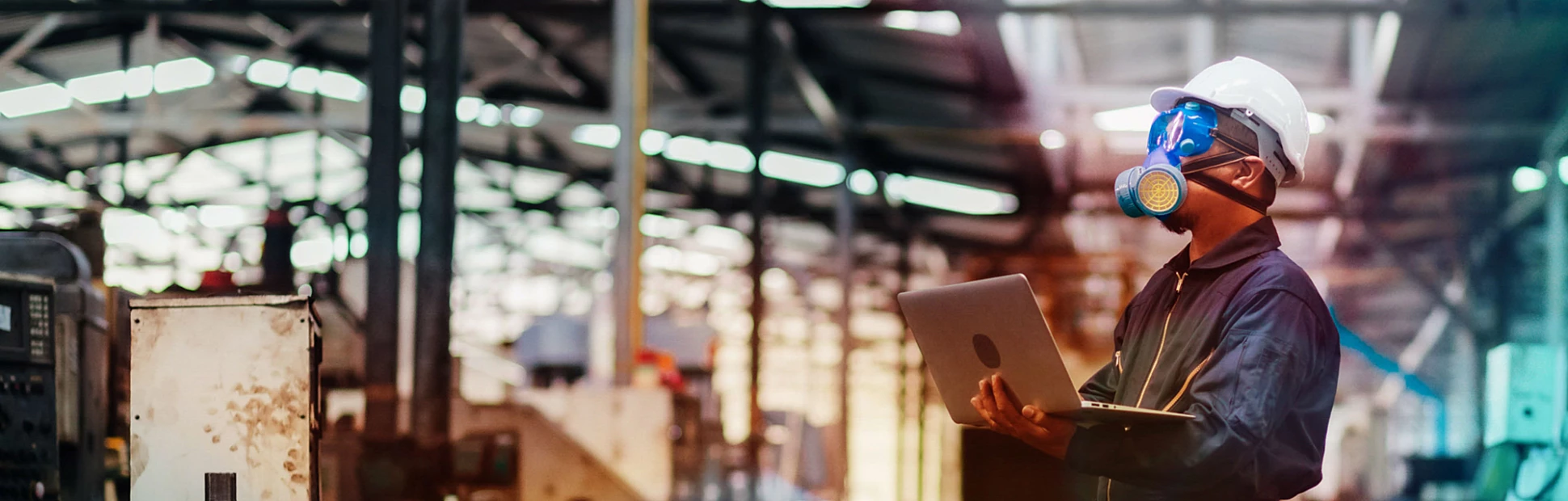 Man with protective mask and computer laptops in factory is investigating a chemical plant.