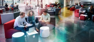 Students sitting in university atrium, three in foreground