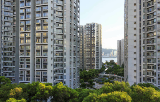 城市里的摩天大楼,建筑的底部有一个公园,背景是美丽的水