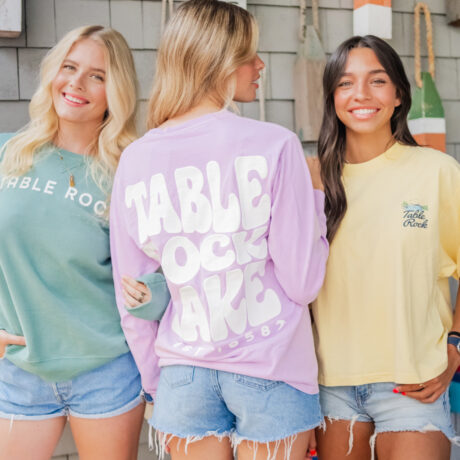 Three women model pastel shirts at State Park Marina’s Boathouse Boutique.