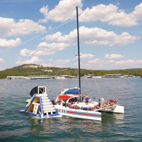 State Park Marina’s Spirit of America catamaran floats on Table Rock Lake with an inflatable swim slide at the stern.
