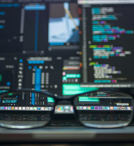 Foto de óculos de grau e no fundo a tela de um computador