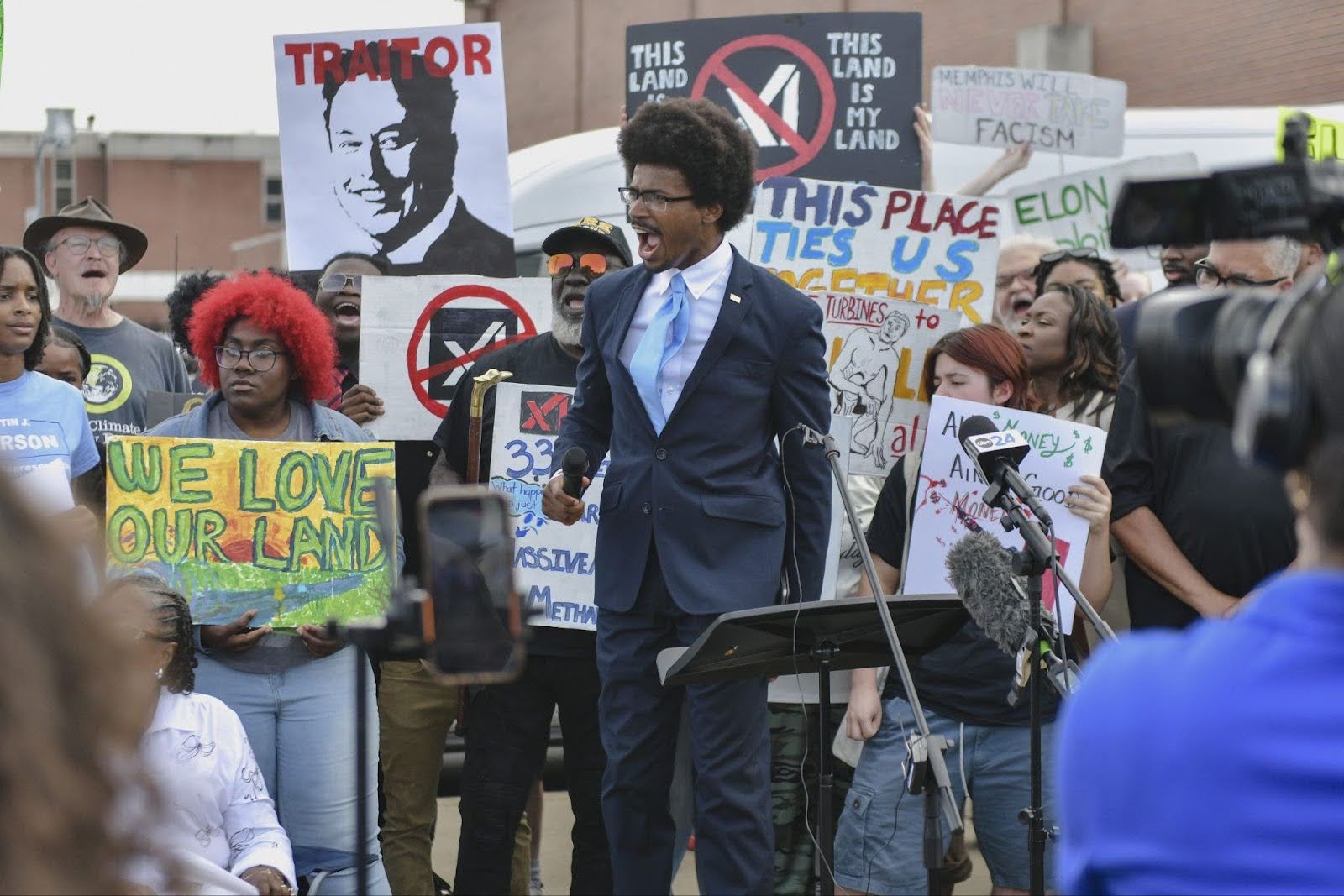 Justin speaking at a rally surrounded by activists with signs opposing Elon Musk's xAI data center.