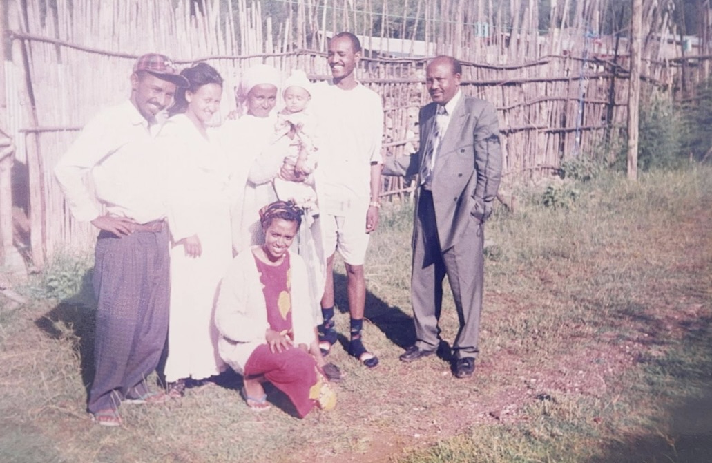 An old picture of Melat and her family standing in front of a fence.