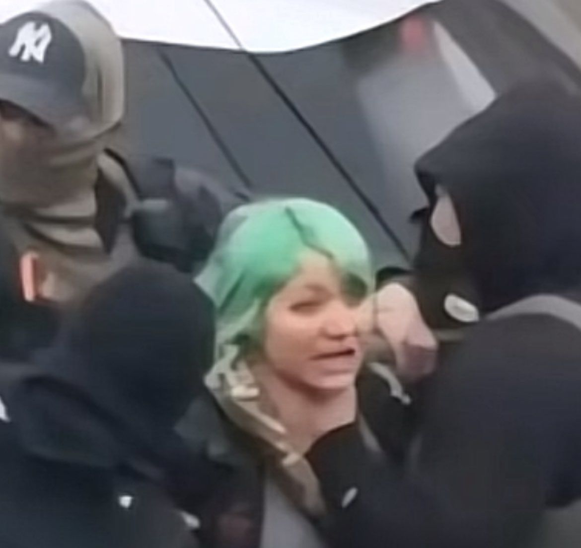 Photo of a young woman being choked by ICE.