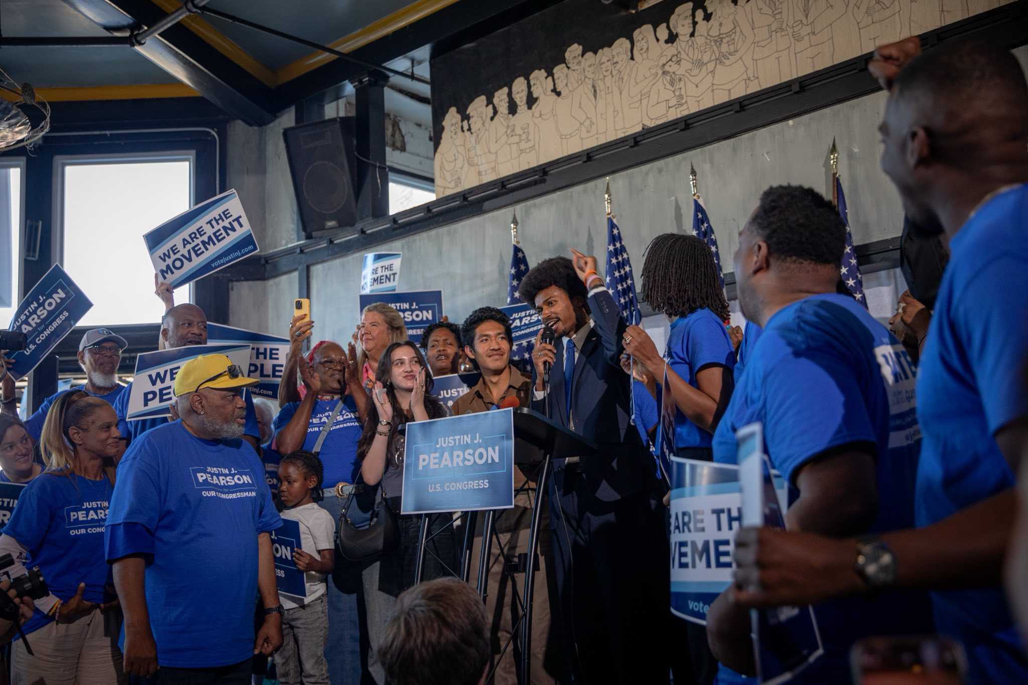 Photo of Justin Pearson surrounded by community members at a rally