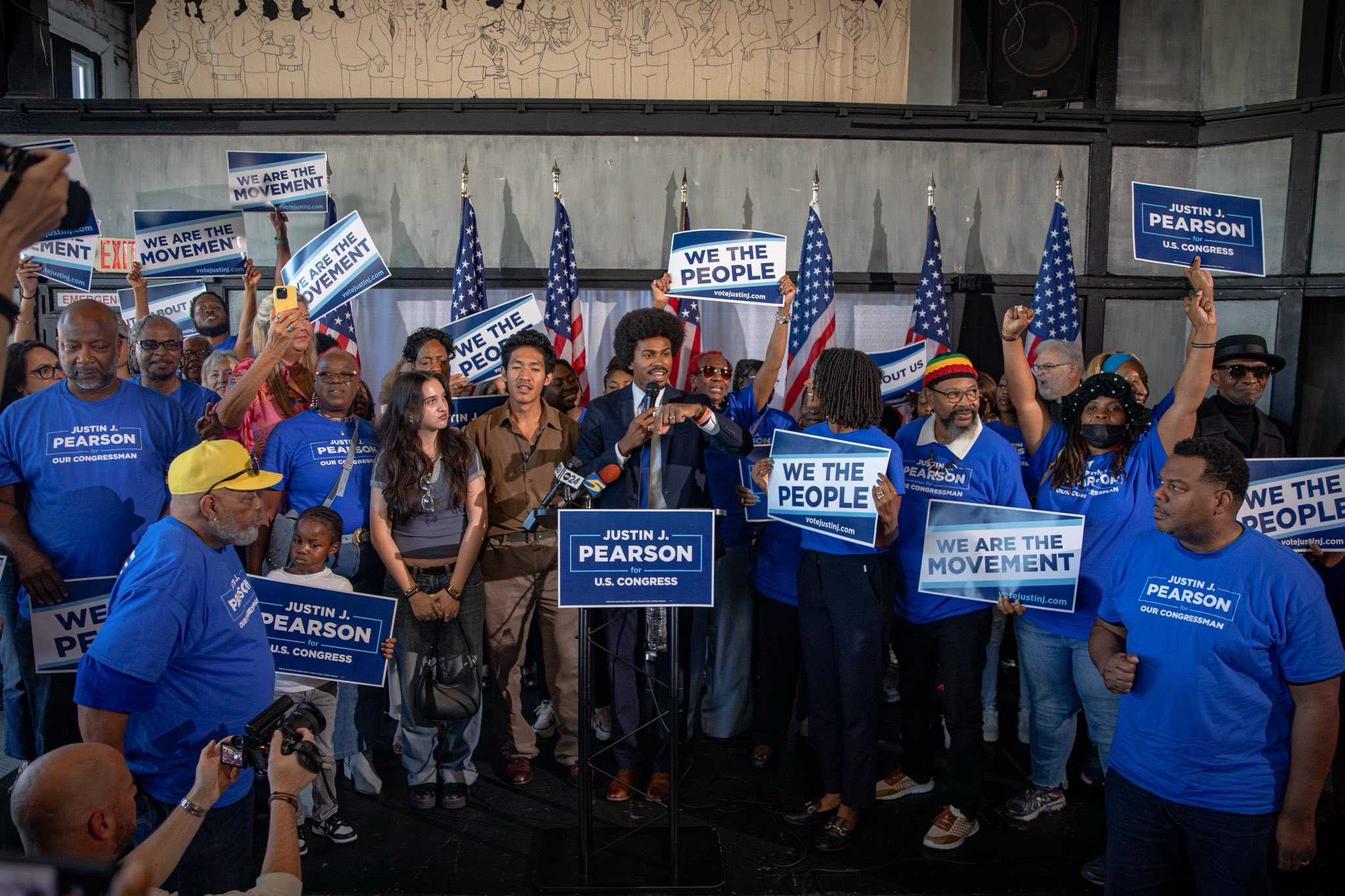 Photo of Justin surrounded by community members at a rally