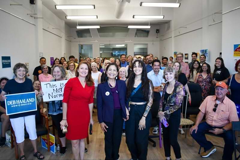 Image from the opening of Deb Haaland's campaign HQ, with Deb standing in the foreground and supporters in the background