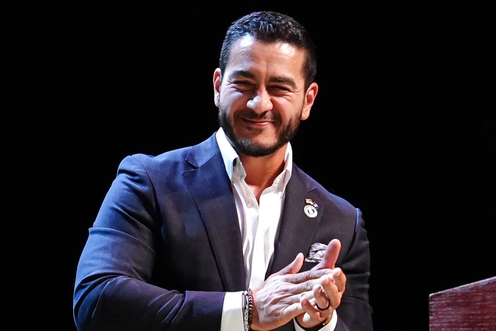 Abdul El-Sayed applauding at podium