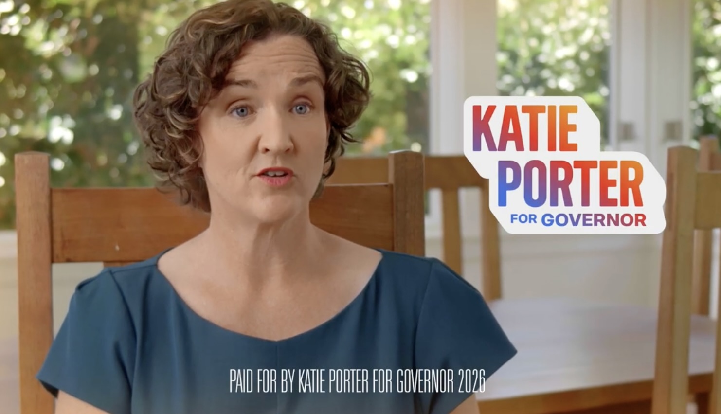 A screenshot from a video of Katie Porter sitting in a wooden chair speaking into the camera. A 'Katie Porter for Governor' logo is on screen.
