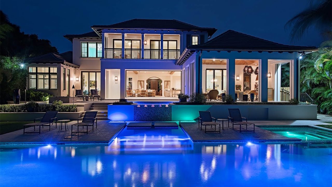Waterfront estate with a lit pool at night