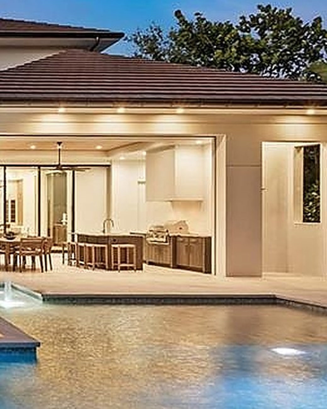Arched entry wing of the estate with patio loungers and a lit spa