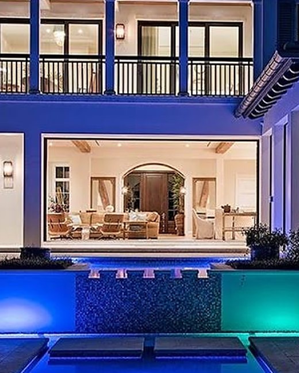 Covered pergola and outdoor lounge beside the pool at dusk