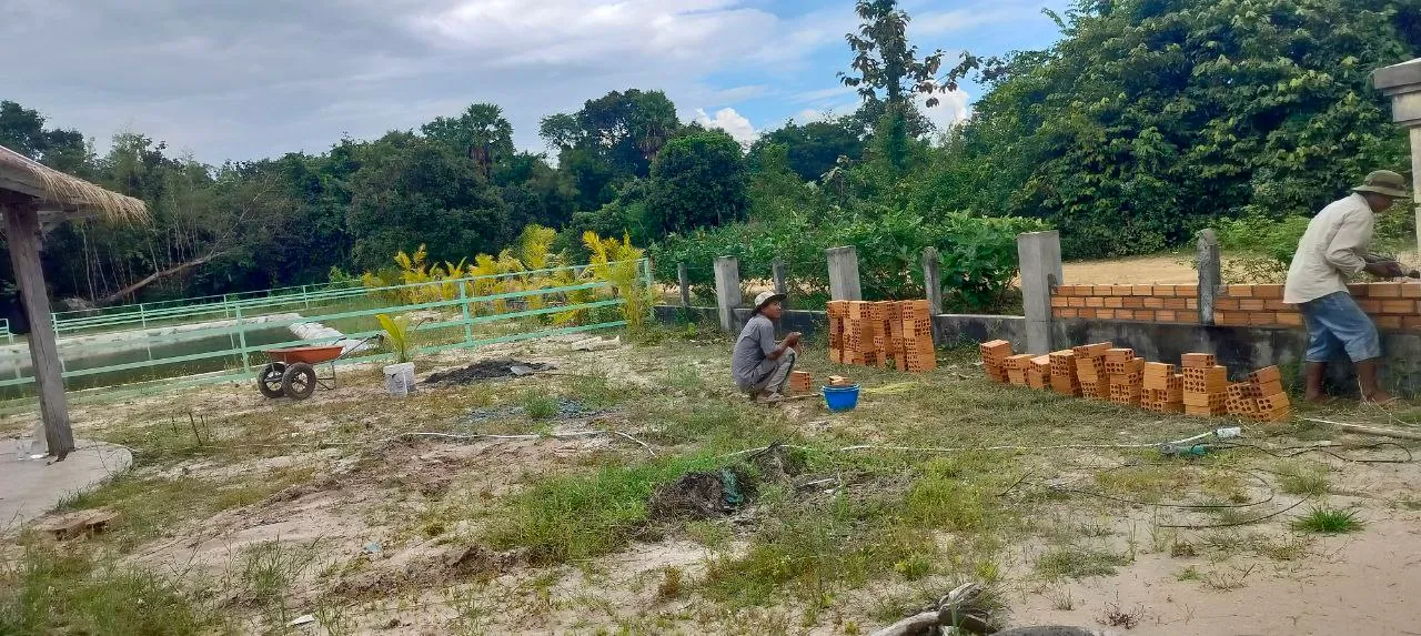 Workers laying a brick wall along the edge of the Children's Center grounds