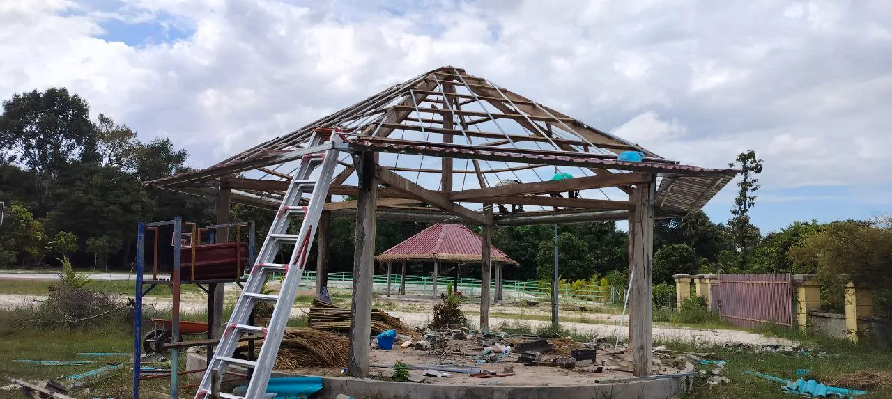 A gazebo stripped down to its wooden frame during the remodel, with a finished gazebo in the background