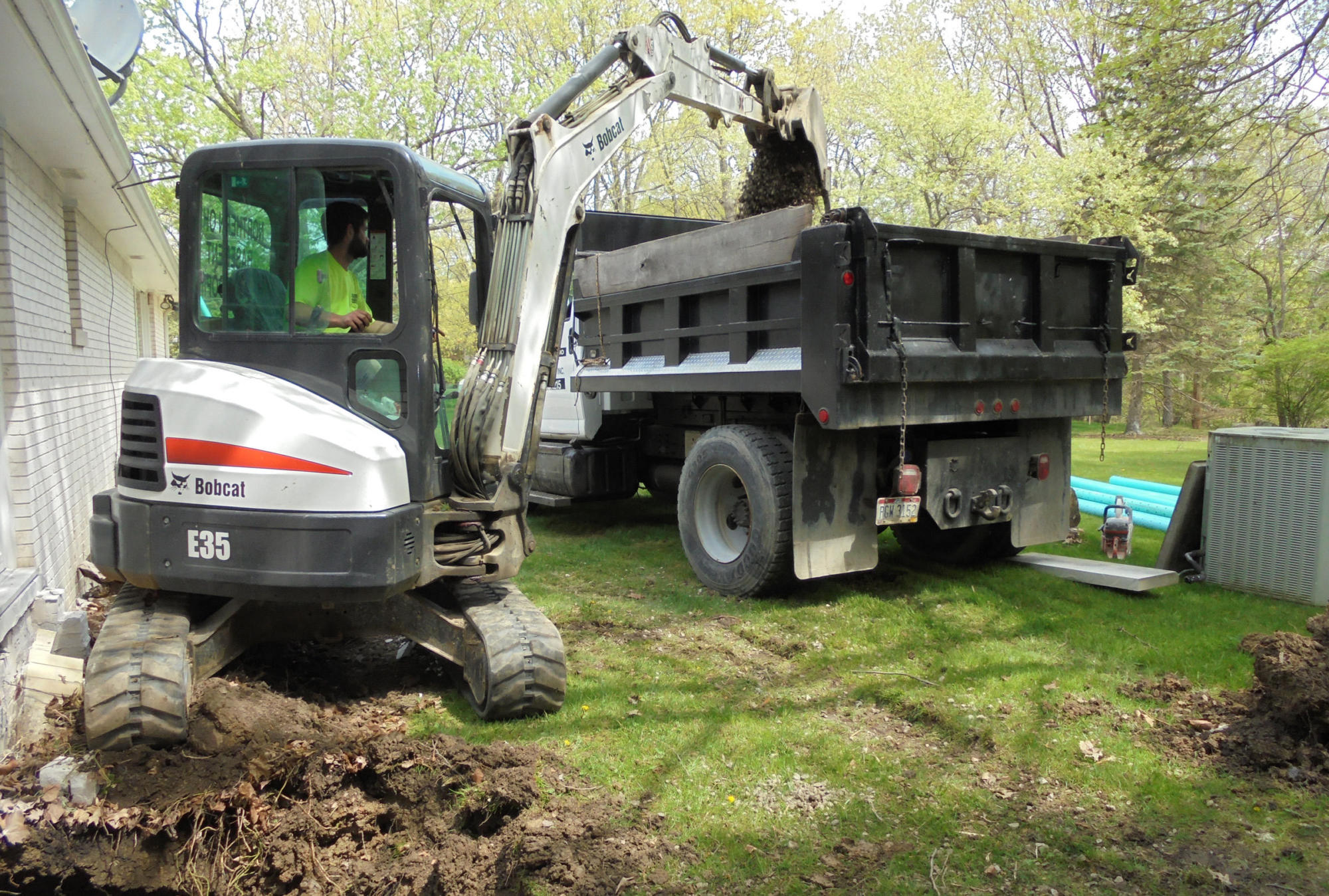 Excavator and truck at a basement waterproofing project