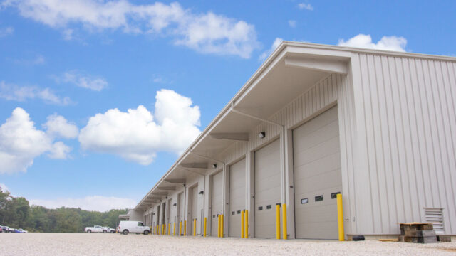 Pre-engineered metal building with steel exterior and commercial overhead doors, designed for fire resistance and long-term insurance durability.