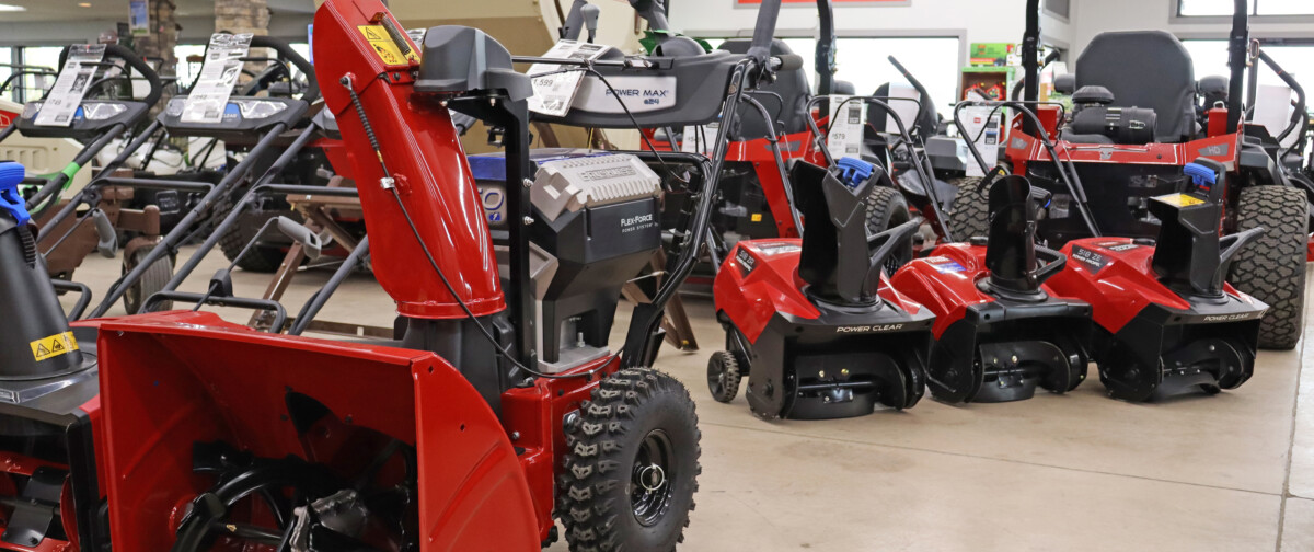 A collection of snowblowers for sale in a store showroom