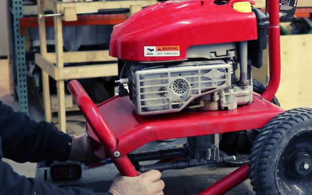 A person preparing to find the model number on their pressure washer