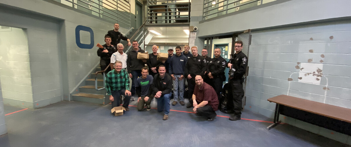 Officers pose with volunteers from The ROP Shop and Outdoor Concepts who participated in Christmas Behind Bars.