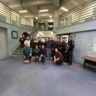 Officers pose with volunteers from The ROP Shop and Outdoor Concepts who participated in Christmas Behind Bars.