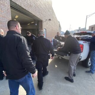 Officers helping unload gifts brought to hand out to inmates for Christmas Behind Bars through the volunteers at The ROP Shop and Outdoor Concepts.