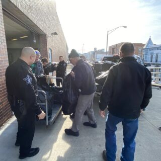 Officers helping unload gifts brought to hand out to inmates for Christmas Behind Bars through the volunteers at The ROP Shop and Outdoor Concepts.