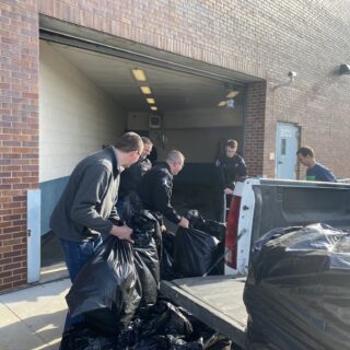 Officers helping unload gifts brought to hand out to inmates for Christmas Behind Bars through the volunteers at The ROP Shop and Outdoor Concepts.