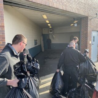 Officers helping unload gifts brought to hand out to inmates for Christmas Behind Bars through the volunteers at The ROP Shop and Outdoor Concepts.