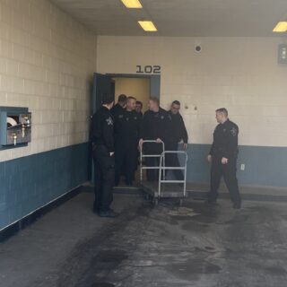 Officers helping unload gifts brought to hand out to inmates for Christmas Behind Bars through the volunteers at The ROP Shop and Outdoor Concepts.