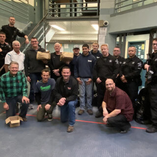 Officers pose with volunteers from The ROP Shop and Outdoor Concepts who participated in Christmas Behind Bars.