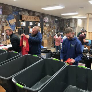 Employees of The ROP Shop and Outdoor Concepts sort and pack clothing to be shipped out by Forgotten Children Worldwide to needy around the world.