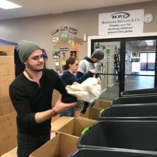 Employees of The ROP Shop and Outdoor Concepts sort and pack clothing to be shipped out by Forgotten Children Worldwide to needy around the world.