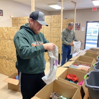 Employees of The ROP Shop and Outdoor Concepts sort and pack clothing to be shipped out by Forgotten Children Worldwide to needy around the world.