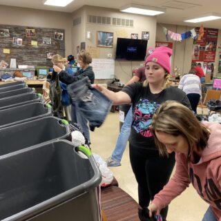 Employees of The ROP Shop and Outdoor Concepts sort and pack clothing to be shipped out by Forgotten Children Worldwide to needy around the world.