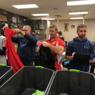 Employees of The ROP Shop and Outdoor Concepts sort and pack clothing to be shipped out by Forgotten Children Worldwide to needy around the world.