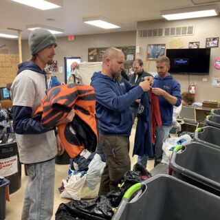Employees of The ROP Shop and Outdoor Concepts sort and pack clothing to be shipped out by Forgotten Children Worldwide to needy around the world.