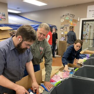 Employees of The ROP Shop and Outdoor Concepts sort and pack clothing to be shipped out by Forgotten Children Worldwide to needy around the world.