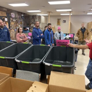 Employees of The ROP Shop and Outdoor Concepts sort and pack clothing to be shipped out by Forgotten Children Worldwide to needy around the world.
