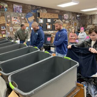 Employees of The ROP Shop and Outdoor Concepts sort and pack clothing to be shipped out by Forgotten Children Worldwide to needy around the world.