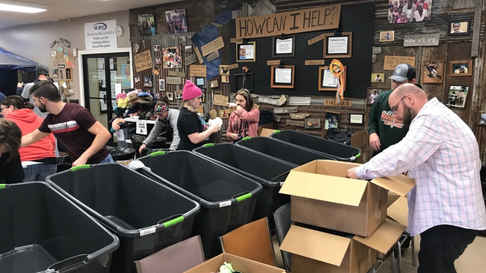 Employees of The ROP Shop and Outdoor Concepts sort and pack clothing to be shipped out by Forgotten Children Worldwide to needy around the world.