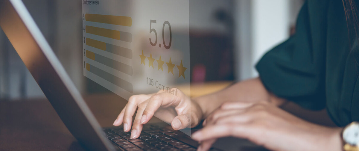 Man on computer and phone giving the viewer the thumbs up.