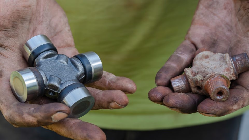 Man holding a new and a used part