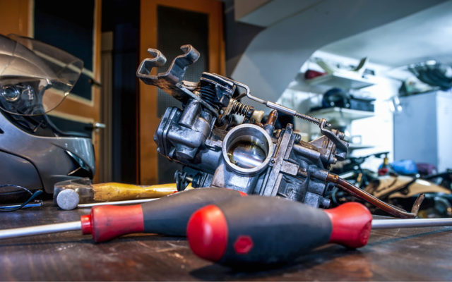 Image of a carburetor being worked on.