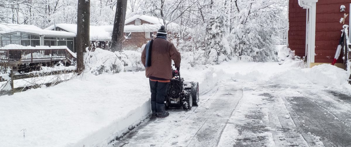 Man clearing his driveway of snow.