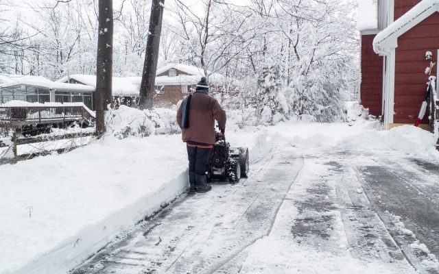 Man clearing his driveway of snow.