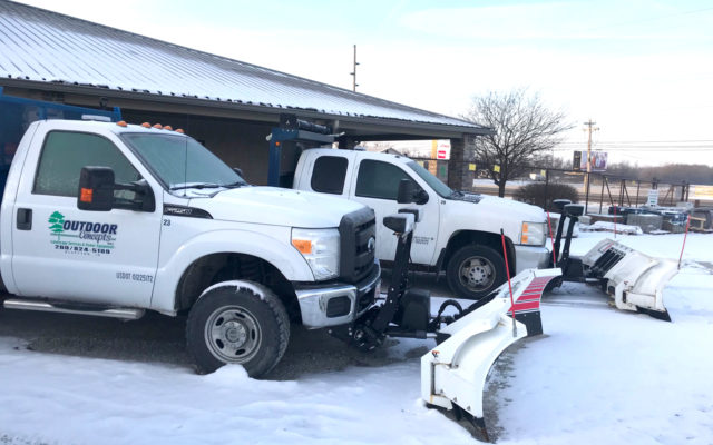 Two Outdoor Concepts trucks with snowplow attachments.